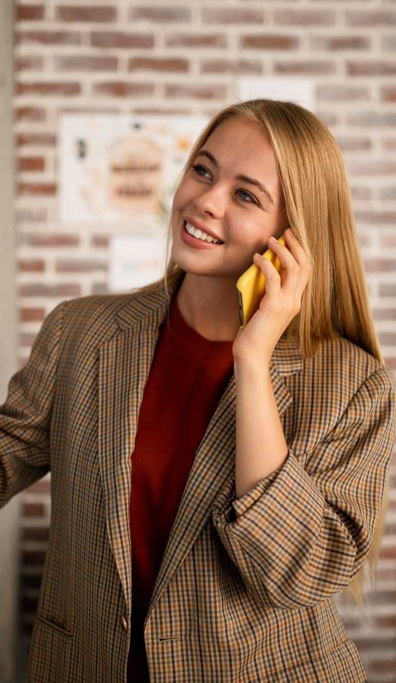 medium-shot-smiley-woman-talking-phone-min